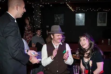 Yorkshire Wedding Magician Adrian Salamon Performing A Magic Trick For A Laughing Bride And Groom During Their Reception. - Hospitium, York